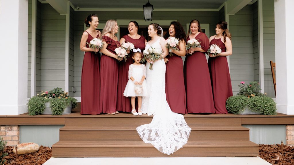 Bridal party on the front porch of a chic rustic wedding
