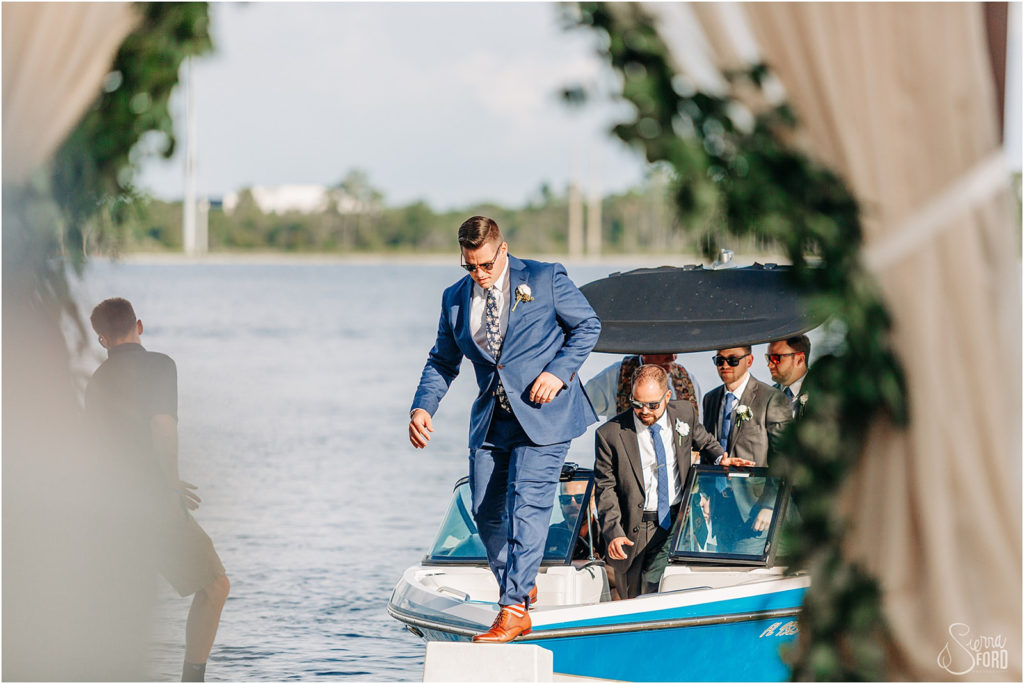 Groom walking off a boat during the wedding processional 