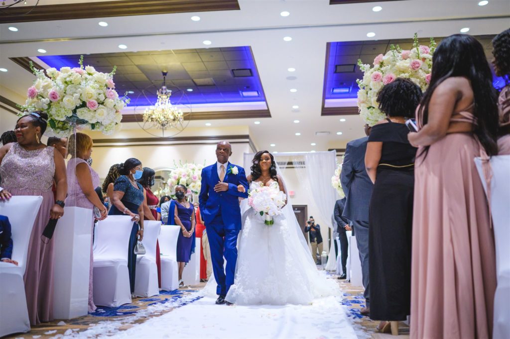 A Haitian bride and her father walking down the aisle during the wedding processional.