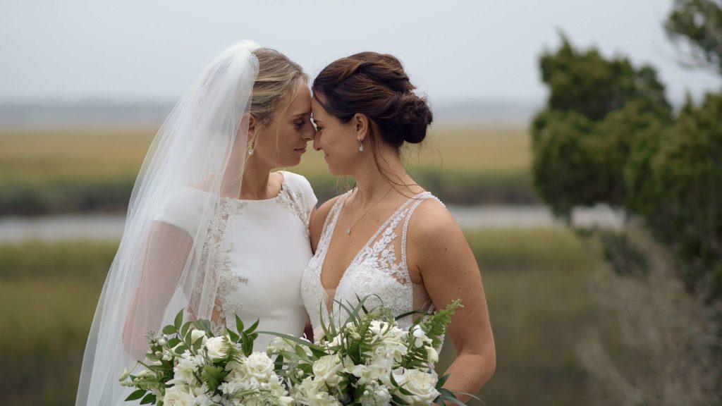 Lesbian couple touching foreheads in a marsh