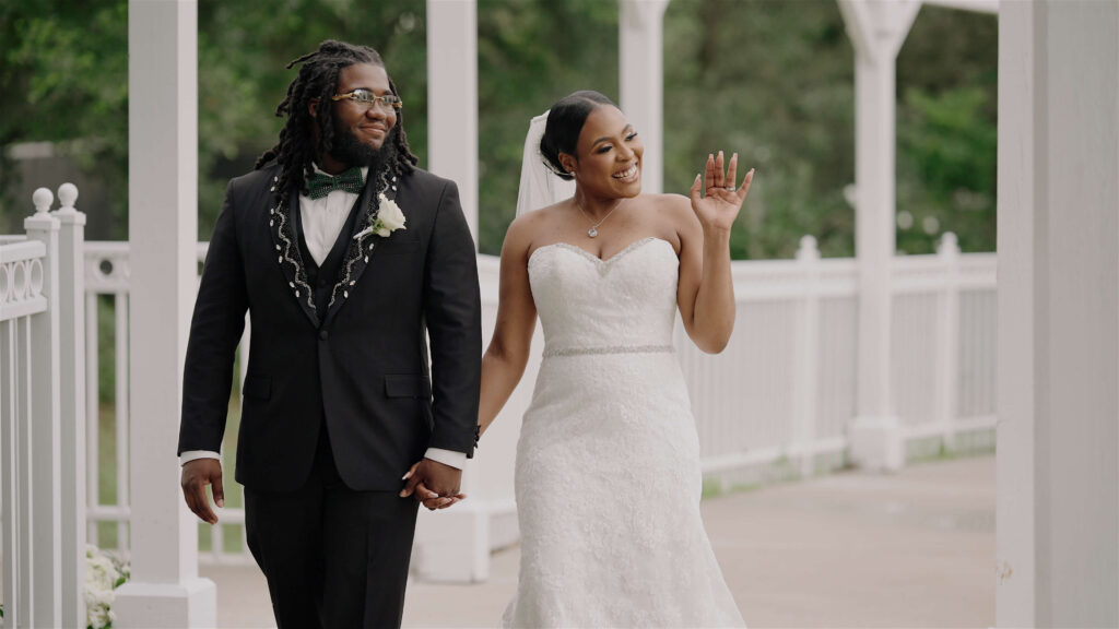 Haitian bride and groom waving off camera